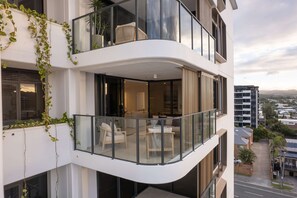 Eine moderne Wohnung mit Balkon, großen Fenstern und Blick auf die Stadt.