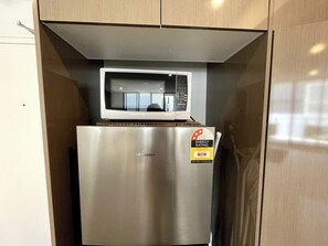 A stainless steel refrigerator with a Hisense microwave on top. - Modern 2Brs@ close2 Olympic park (Wentworth Point)
