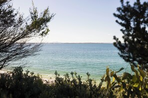 A coastal landscape with a clear view of the sea and distant mountains. - Berrigal 4 Beachfront (Shoal Bay)