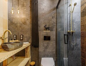 A modern bathroom with a stone sink, a glass shower enclosure, and a deer's statue on the wall. - Holiday Home in the Mountains, Sauna, Jacuzzi (Poronin)