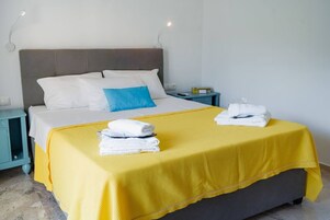 Una habitación de hotel con cama, mesita de noche y mesilla.