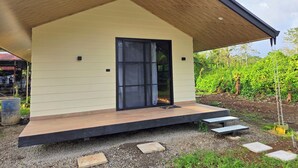 Een modern huis met een schuin dak, een grote schuifpui en een klein terras.