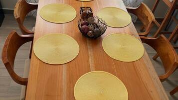 Una mesa de comedor de madera con seis individuales redondos y un centro de mesa decorativo.