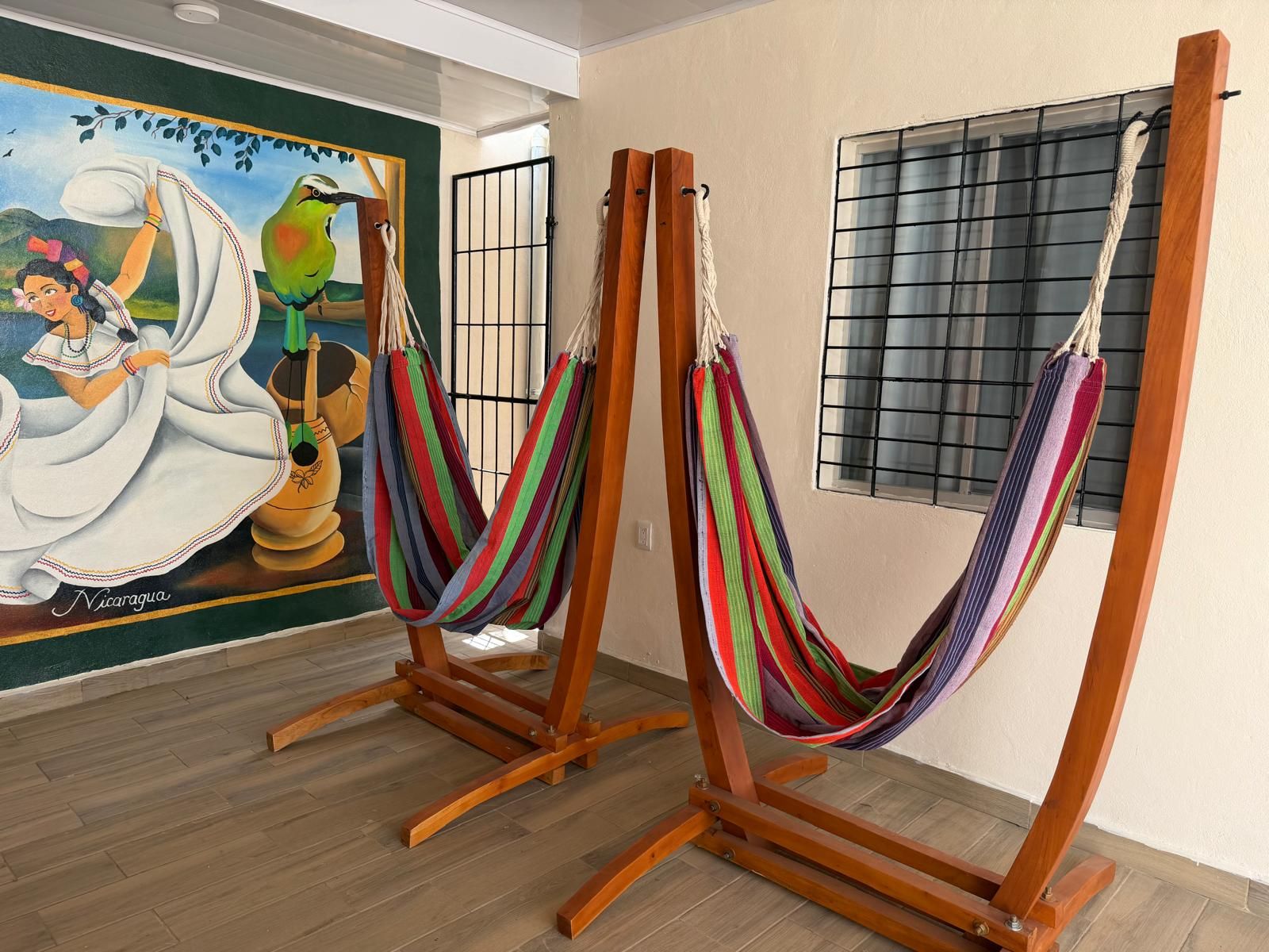 Una habitació amb dues gandules de fusta i un mural a la paret.