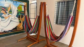 Una habitació amb dues gandules de fusta i un mural a la paret.