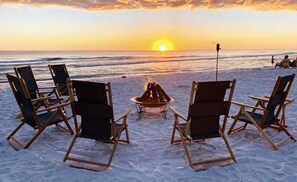A beach scene with a fire pit and chairs facing the ocean at sunset. - 22nd Floor Gulf-Front Escape, Sunrise Beach Resort, Resort Pools, Sleeps 7 (Panama City Beach)