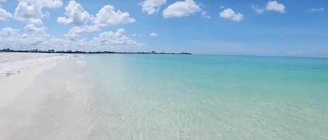 A beach with clear turquoise water and a white sandy shore.