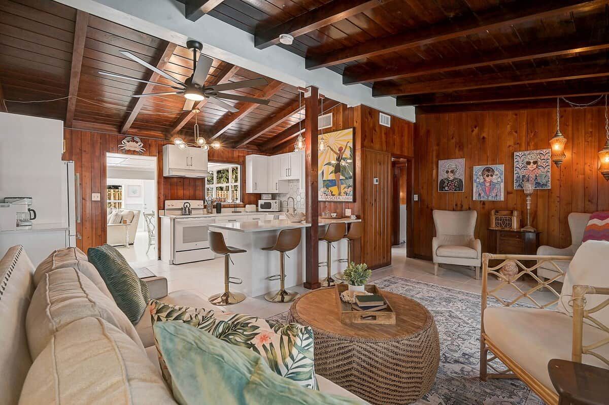 A spacious living area with a sofa, a coffee table, and a kitchen in the background.