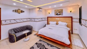 Un dormitorio moderno con cama, sofá y un elemento decorativo en la pared.