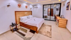 Un dormitorio moderno con cama de madera, mesita de noche y escritorio con silla.