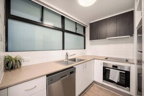 Eine moderne Küche mit Geschirrspüler, Backofen und einem Fenster mit satinierten Glasscheiben.