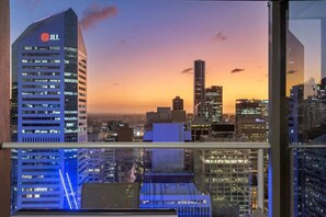 Blick auf eine Stadtlandschaft von einem Hochhaus mit einem gut sichtbaren JLL-Schild, moderner Architektur und einem Sonnenuntergang.