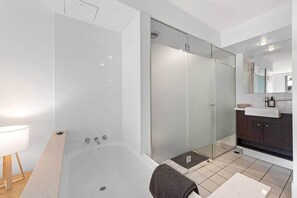 A modern bathroom with a glass-enclosed shower, a bathtub, and a vanity with a mirror. - Inner City Action! 3bed/2bath/1car/3balconies (Brisbane)
