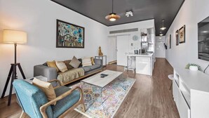 A modern living room with a sofa, coffee table, and a colorful rug. - Central & Stylish! 1bed/1bath/1car ~ 5 Mins to CBD (Brisbane)