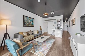 A modern living room with a sofa, coffee table, and a colorful rug. - Central & Stylish! 1bed/1bath/1car ~ 5 Mins to CBD (Brisbane)