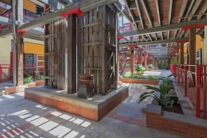 An outdoor area with a wooden structure, a fire pit, and potted plants. - Woolstore Style! ~ 2bed/2bath/1car ~ Teneriffe (Brisbane)