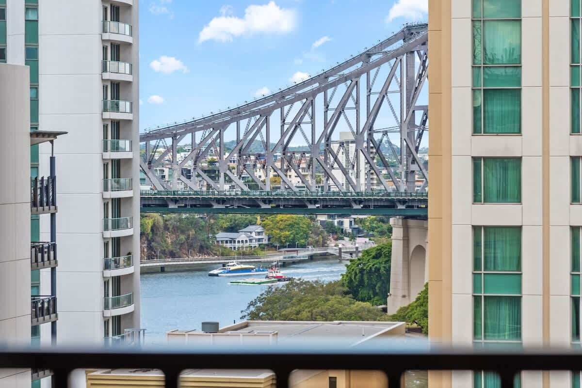 A view of a bridge over a river with buildings in the foreground.