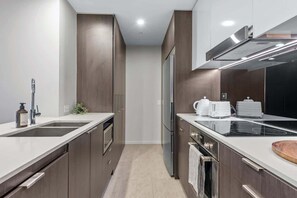 A modern kitchen with a double sink, stainless steel appliances, and a built-in oven. - Modern Style! 1bed/1bath/balcony/pool ~ CBD (Brisbane)