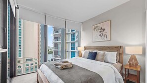 A modern hotel room with a large bed, a view of the city, and a balcony. - Modern Style! 1bed/1bath/balcony/pool ~ CBD (Brisbane)