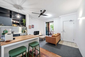 Eine moderne Küche mit Barbereich, einer Couch und einem Fernseher.