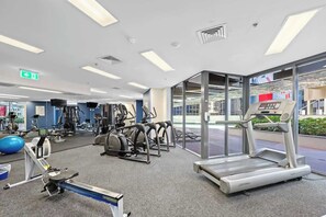 Ein Fitnessstudio mit Laufbändern, Crosstrainern und Gewichten.