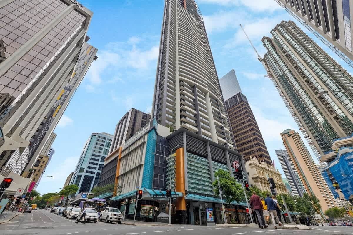 A tall urban building with a modern design, surrounded by other high-rise structures.