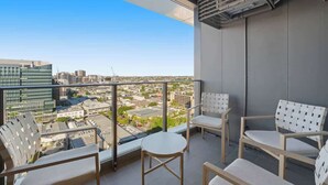 Ein Balkon mit Blick auf die Stadt, ein Tisch und vier Stühle.