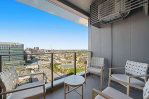 Ein Balkon mit Blick auf die Stadt, ein Tisch und vier Stühle.