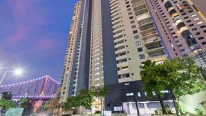 A high-rise building with multiple floors, balconies, and a well-lit facade. - The Executive! 1bed, 1bath, 1car, Views ~ CBD (Brisbane)