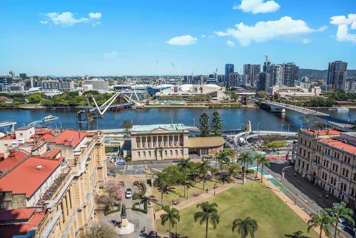 A cityscape with a river, a bridge, and a prominent building with classical architecture.