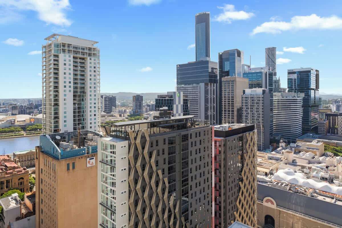 A cityscape with modern high-rise buildings, including a distinctive building with a diamond-patterned facade.