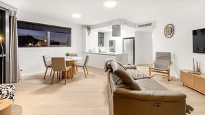 A modern interior with a dining area, sofa, and kitchen. - Amazing! 2bed/2bath/1car/balcony/views ~ CBD (Brisbane)