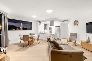 A modern interior with a dining area, sofa, and kitchen. - Amazing! 2bed/2bath/1car/balcony/views ~ CBD (Brisbane)