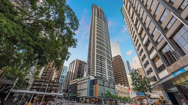 A modern urban street with high-rise buildings, a pedestrian crossing, and a traffic light. - Amazing! 2bed/2bath/1car/balcony/views ~ CBD (Brisbane)