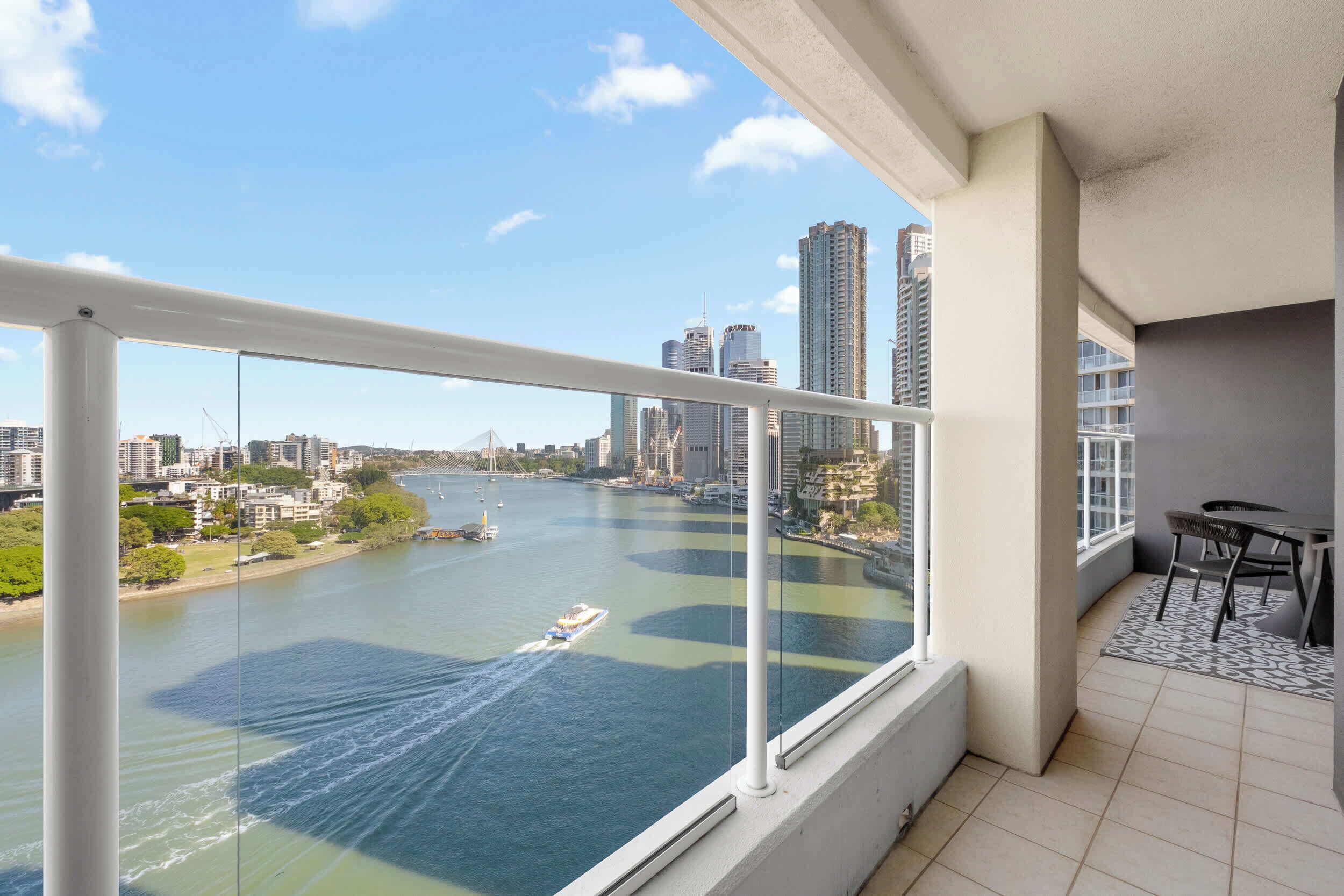 A balcony with a city view, a table, and chairs.
