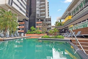 A swimming pool with lounge chairs, surrounded by modern buildings with balconies. - South Bank Sensational! ~ 1bed,1bath,1car,balcony (Brisbane)