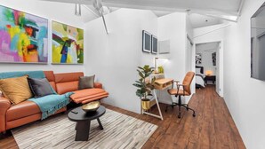 Ein modernes Wohnzimmer mit Sofa, Couchtisch und einem Kunstwerk an der Wand.