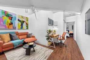 A modern living room with a sofa, coffee table, and artwork on the wall. - Woolstore Elegance ~ 2bed/2bath/1car ~ Teneriffe (Brisbane)