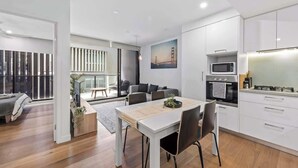 A modern apartment with a dining area, kitchen, and a balcony with a view. - South Bank Sleek! ~ 1bed/1bath/1car/balcony (Brisbane)