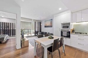 Eine moderne Wohnung mit Essbereich, Küche und einem Balkon mit Blick.