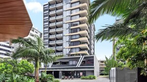 A modern multi-story building with balconies, surrounded by greenery and other buildings. - South Bank Sleek! ~ 1bed/1bath/1car/balcony (Brisbane)
