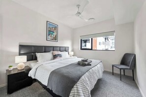 A bedroom with a bed, a nightstand, a chair, a ceiling fan, a window, and a picture on the wall. - South Bank Styling! ~ 1bed, 1bath, 1car, Balcony (Brisbane)