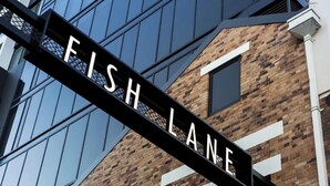 Um edifício com uma placa que diz 'FISH LANE'.