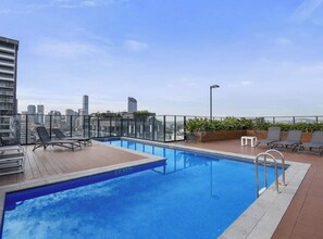 A rooftop pool with lounge chairs, a view of the city skyline, and a clear sky. - South Bank Styling! ~ 1bed, 1bath, 1car, Balcony (Brisbane)