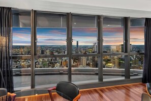 A high-rise room with large floor-to-ceiling windows, a wooden floor, and a black office chair. - Skyhigh Executive! ~ 2bed/2bath/1car/views ~ CBD (Brisbane)