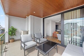 Ein Balkon mit zwei Stühlen, einem Tisch und einem Blumentopf.