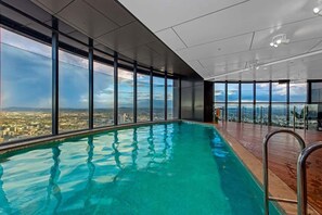 Ein moderner, überdachter Pool mit großen Fenstern und Blick auf die Stadt.