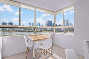 Une chambre avec vue sur la ville, une table et deux chaises.