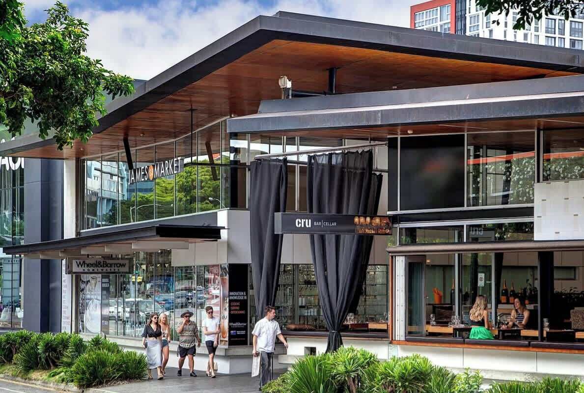 A modern building with a glass facade, a wooden ceiling, and a sign for 'James Market.'