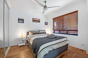 A bedroom with a bed, a nightstand, a ceiling fan, and a window with blinds. - Point Peninsula - 2bed-2bath-car-pool - Teneriffe (Brisbane)